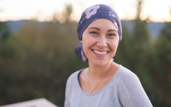 iStock image of a cancer patient smiling with head scarf | Icon Cancer Centre